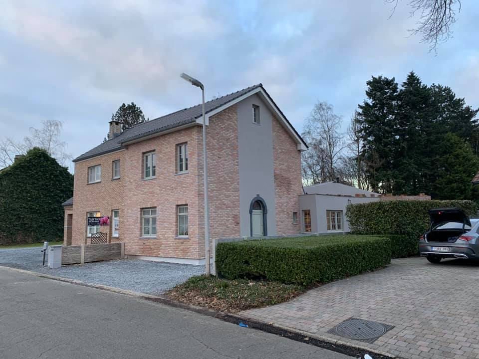 Woning met zachtroze gevelbepleistering na renovatie